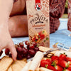 Bakers Provita Wholewheat Crispbread 250g with grapes and strawberries on a picnic blanket.