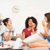 Three women enjoying Bakers Tennis Biscuits on a cozy sofa, highlighting social moments with the classic South African treat.