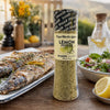 Cape Herb & Spice Lemon Pepper Shaker 290g beside grilled fish, salad and lemon at an outdoor meal