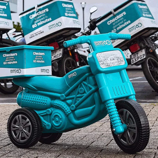 Teal plastic motorbike with helmet for kids, featuring Checkers Sixty60 branding and delivery box.
