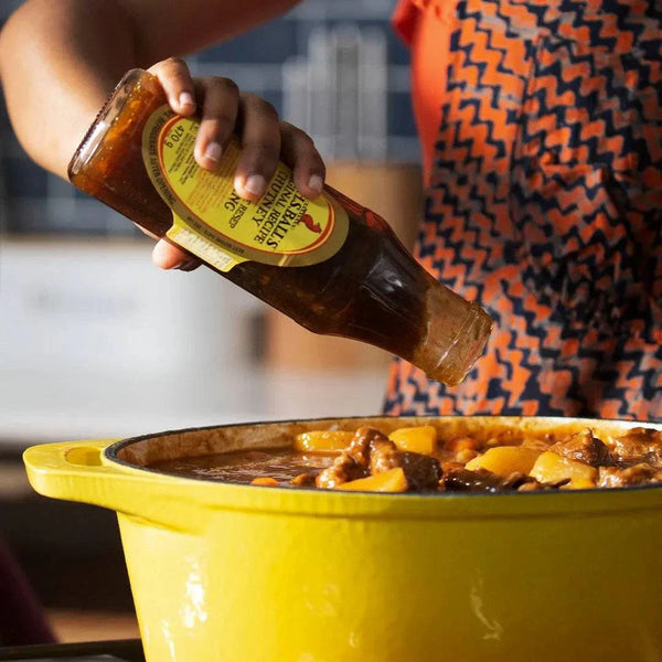Mrs Balls Chutney Original 1.1kg jar being poured over a pot of stew.