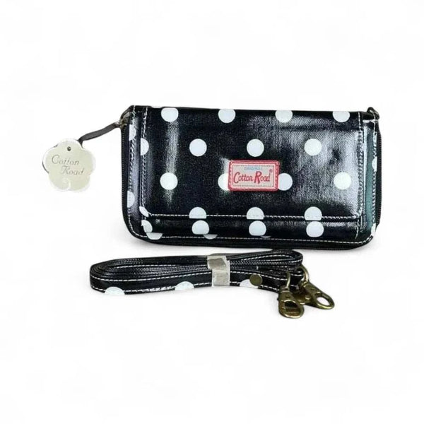Black sling wallet with large white dots and removable shoulder strap by Cotton Road