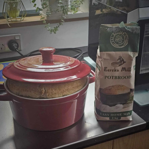 Eureka Mills Potbrood Easy Home Mix - 1kg next to freshly baked potbrood in red pot.