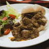 Peri-Peri coated meat with a roll and salad, showcasing Ina Paarman Coat & Cook Sauce.