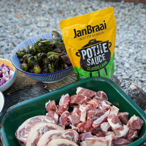 Jan Braai Sauces Classic Lamb Potjie Sauce 400g pouch with raw lamb pieces and vegetables for traditional South African potjie cooking