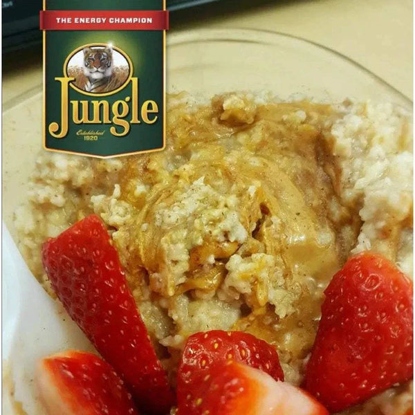 Jungle Oats 1kg box with creamy oatmeal topped with strawberries, showcasing a nourishing breakfast option.
