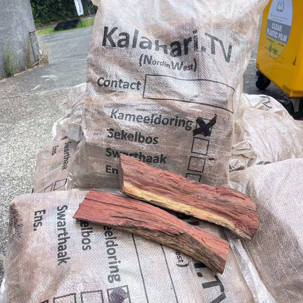 Camel Thorn Firewood bags stacked, showcasing dense, high-quality wood ideal for efficient, low-smoke burning in fireplaces and outdoor cooking.