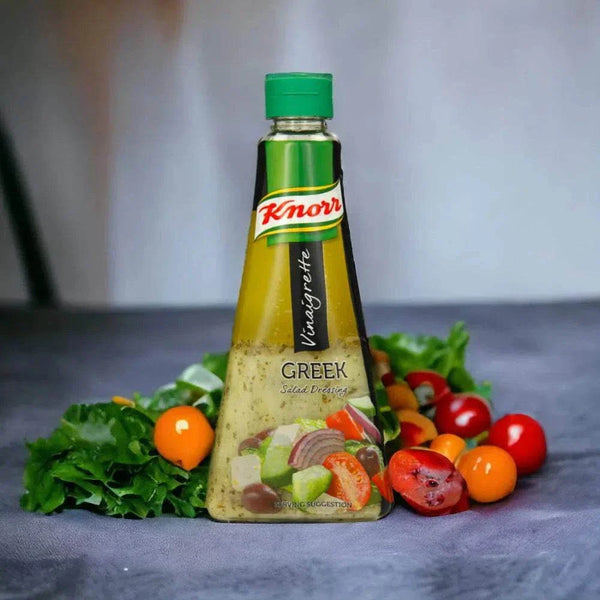 Knorr Vinaigrette Greek Salad Dressing bottle with fresh tomatoes and leafy greens around it