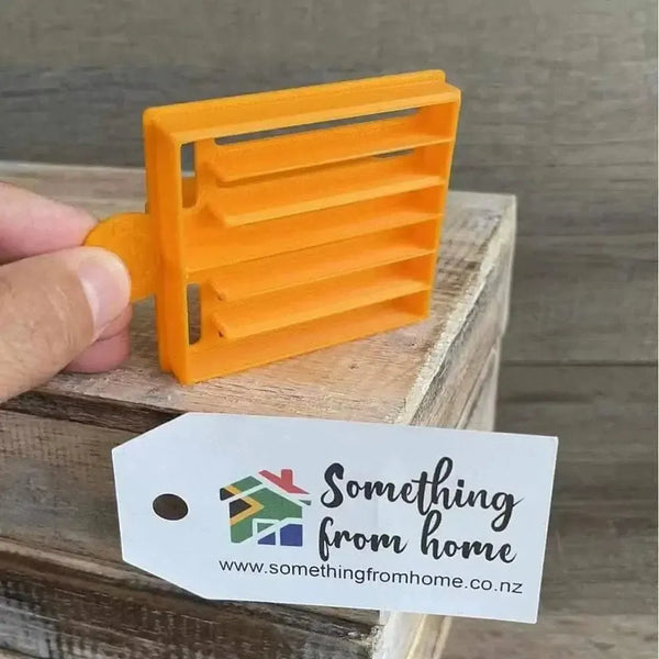 Small orange plastic Koeksister cutter for making traditional Afrikaans fried dough pastries