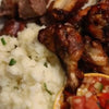 Plate of traditional South African maize meal served with grilled meat and tomato salsa.