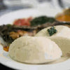 Traditional South African maize meal dish served with vegetables on a white plate