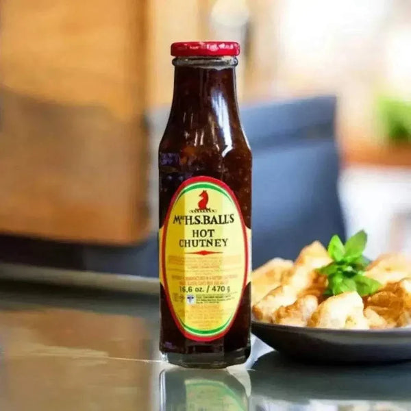 Mrs Balls Chutney Hot 470g jar on a kitchen counter, perfect for spicing up dishes.
