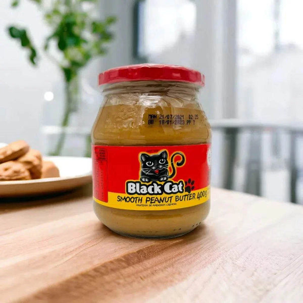 Black Cat smooth peanut butter 400g jar with red lid on wooden surface