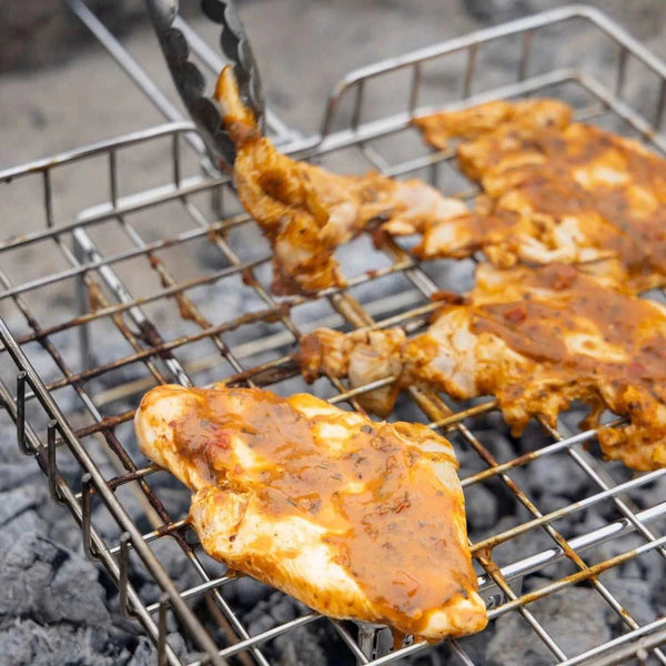 Grilled chicken breasts basted with South African Jan Braai Prego basting sauce on a barbecue grill