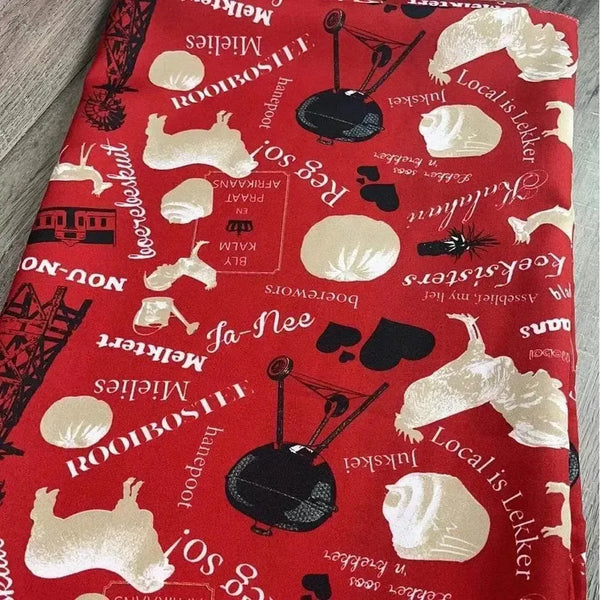 Red tablecloth with Afrikaans sayings and 275cm x 140cm dimensions