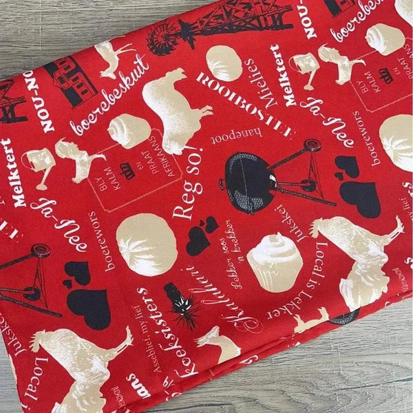 Red tablecloth with Afrikaans sayings and dimensions 275cm by 140cm