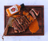 Rooibaard Original Sauce 250ml with sliced meat on a wooden board.