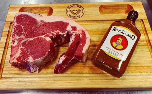 Rooibaard Original Sauce 250ml bottle next to raw steak on wooden board.