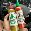 Rooibaard Tabaardsco Rooi Sauce bottle held in hand, next to a green sauce, inside a car.