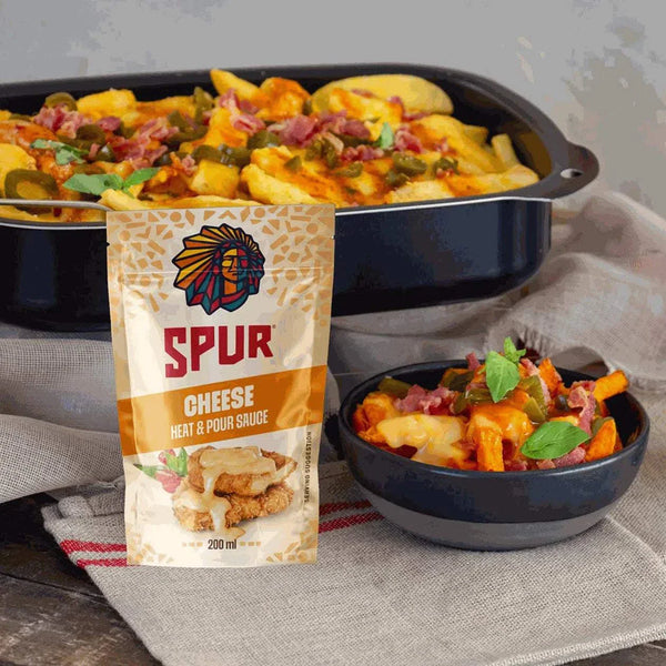 SPUR Sauce Cheese 200ml, thick and creamy cheddar cheese sauce, shown with baked potatoes and bacon.