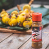 Ina Paarman Chilli & Garlic seasoning - 200ml bottle on table with skewered meats in background.