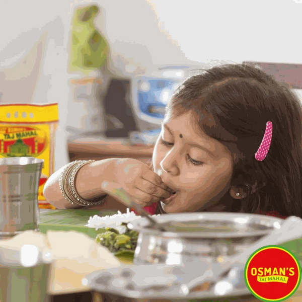 Osmans Durban Masala Spice 100g packet on table with a child enjoying a flavorful meal.