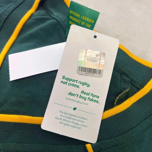 Close-up of green Springbok Official Licensed Supporter T-Shirt tag with yellow trim and anti-counterfeit holographic label