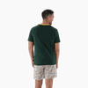 Man wearing 2XL Springbok Pajama Set with green short-sleeve top and white elastic waist shorts with Springbok logo pattern, back view
