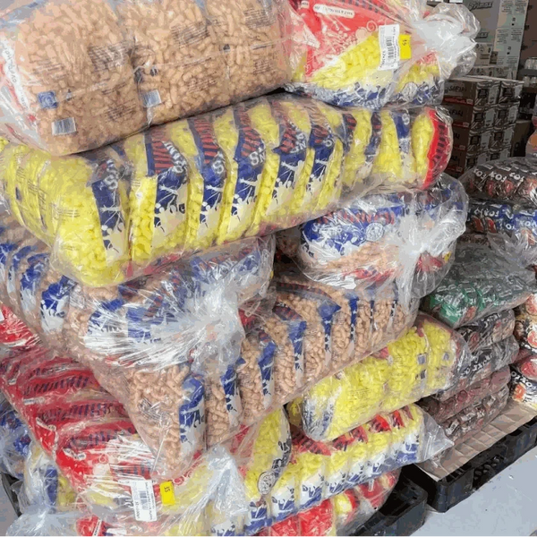 Stacked bulk packages of Yank Snacks Maize Puffs Fruit Chutney flavor in clear plastic bags.
