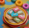 Bakers Zoo Biscuits 150g featuring colorful iced animal shapes on a plate.