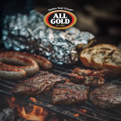 Grilled meats and bread over open flame with All Gold Braai Relish logo above