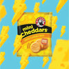 Bakers Mini Cheddars cheese flavored snack pack of 6 on a blue background with cheese graphics.