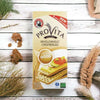 Bakers Provita Wholewheat Crispbread 500g box on a rustic wooden table with scattered crispbread pieces.