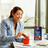 Person enjoying Bakers Romany Classic Choc Coconut Flavour Rusks with a hot beverage in an office setting.