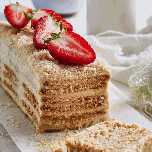 Layered dessert featuring Tennis Biscuits, topped with fresh strawberries.