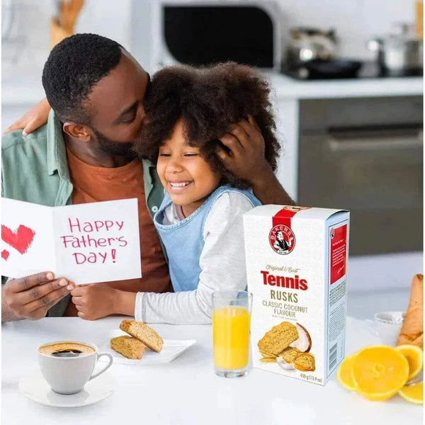 Father and daughter enjoying a heartfelt moment with Bakers Tennis Classic Coconut Rusks, perfect with coffee or juice for Father's Day breakfast.