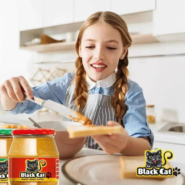 Person spreading Black Cat peanut butter onto toast