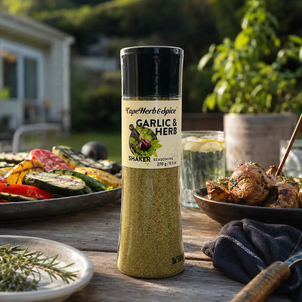 Cape Herb & Spice Garlic & Herb 270g shaker at an outdoor barbeque meal