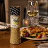 Cape Herb & Spice Lemon Pepper Shaker 290g beside a plated chicken and vegetable dinner