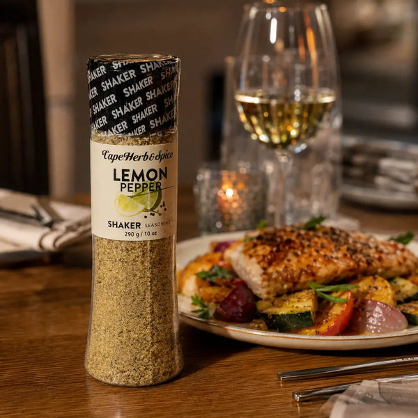 Cape Herb & Spice Lemon Pepper Shaker 290g beside a plated chicken and vegetable dinner