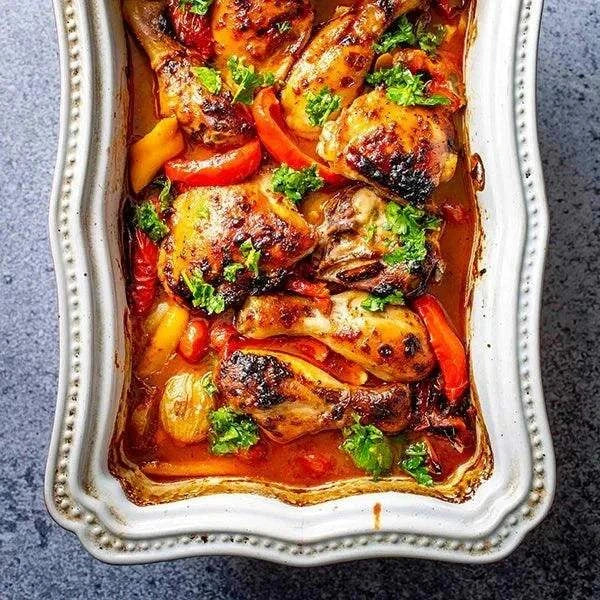 Ina Paarman Chicken Spice herb blend with roasted chicken in white baking dish.