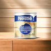 Nestle full cream condensed milk 385g can on a wooden surface.