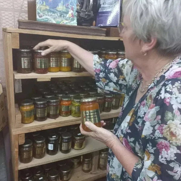 Ina Lessing Green Figs 410ml jar on a wooden shelf, showcasing fig preserves.