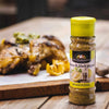 Ina Paarman Lemon & Black Pepper seasoning bottle on wooden surface with roasted chicken.
