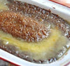 Moist Sticky Malva Pudding with caramelized apricot butter glaze in baking dish.