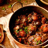 Traditional South African oxtail potjie stew cooked with Jan Braai Classic Oxtail Potjie Sauce garnished with fresh herbs in a rustic pot