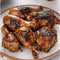 Grilled chicken marinated with All Joy Marinade Chicken in a 750ml bottle, garnished with herbs.