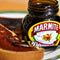 Marmite Yeast Extract 125g jar next to toast spread with Marmite.