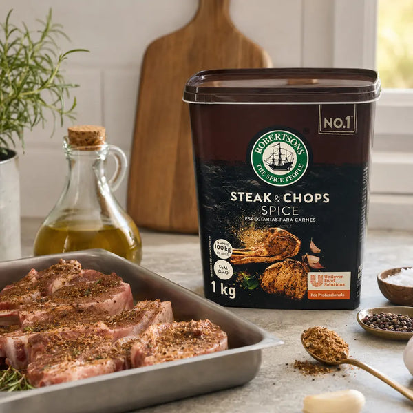 Robertsons Steak & Chops Spice 1kg beside seasoned chops in a home kitchen