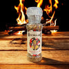 Rooibaard Braai Spice 170g grinder with fiery flames in the background, perfect for enhancing grilled dishes.